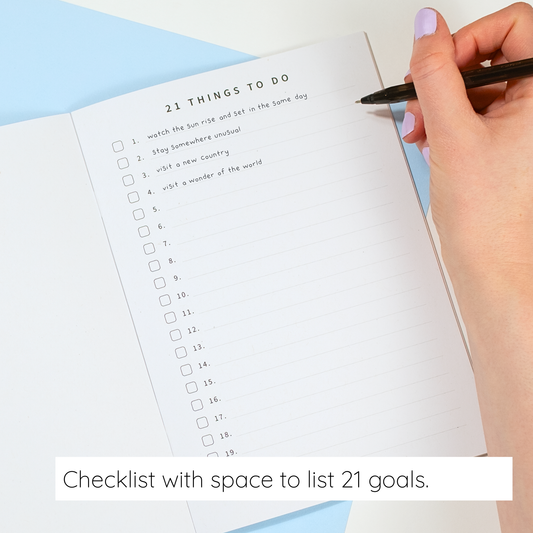 Checklist with space to list 21 goals, held by a hand with a pen.