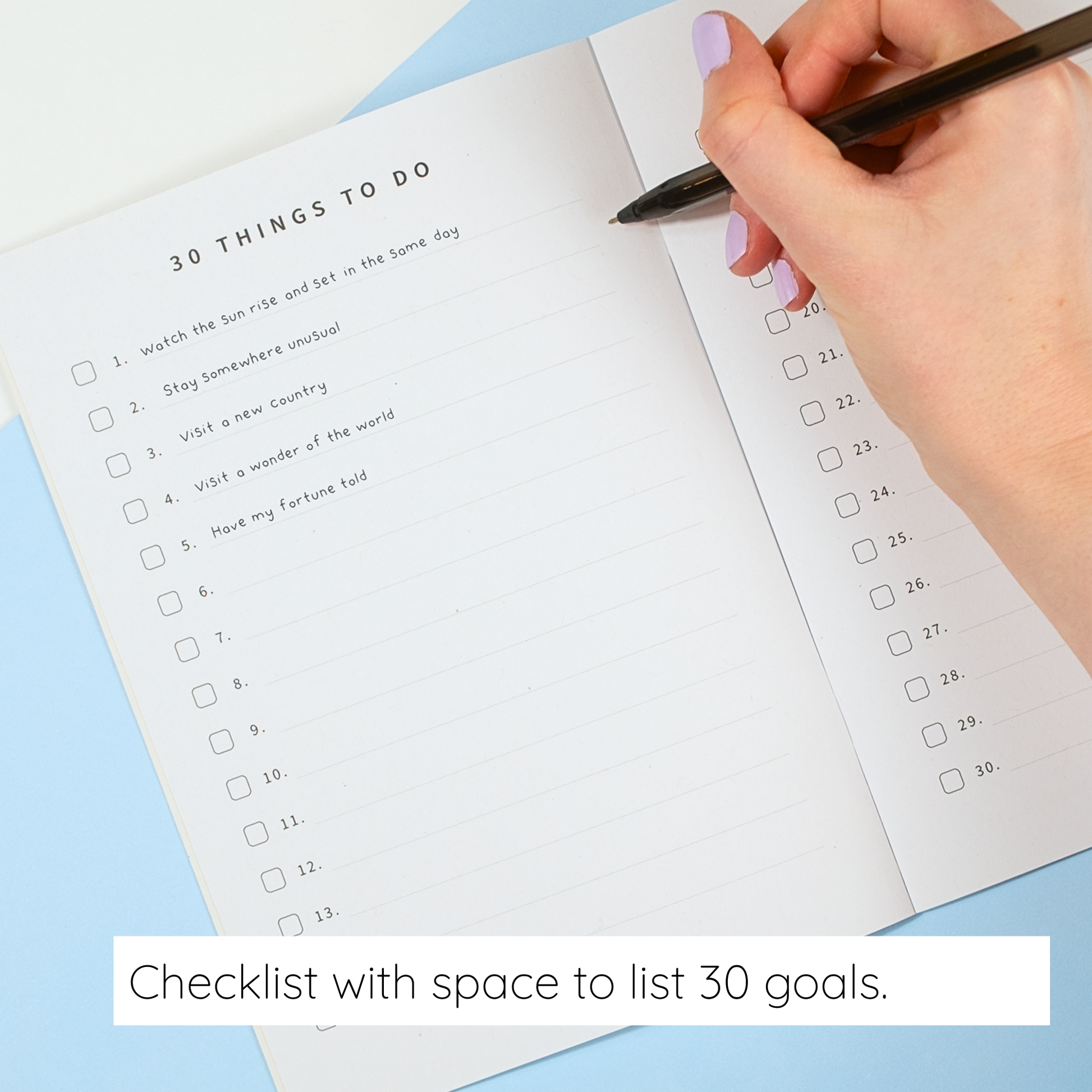 Hand holding a pen over a checklist with space to list 30 goals on a light blue background.
