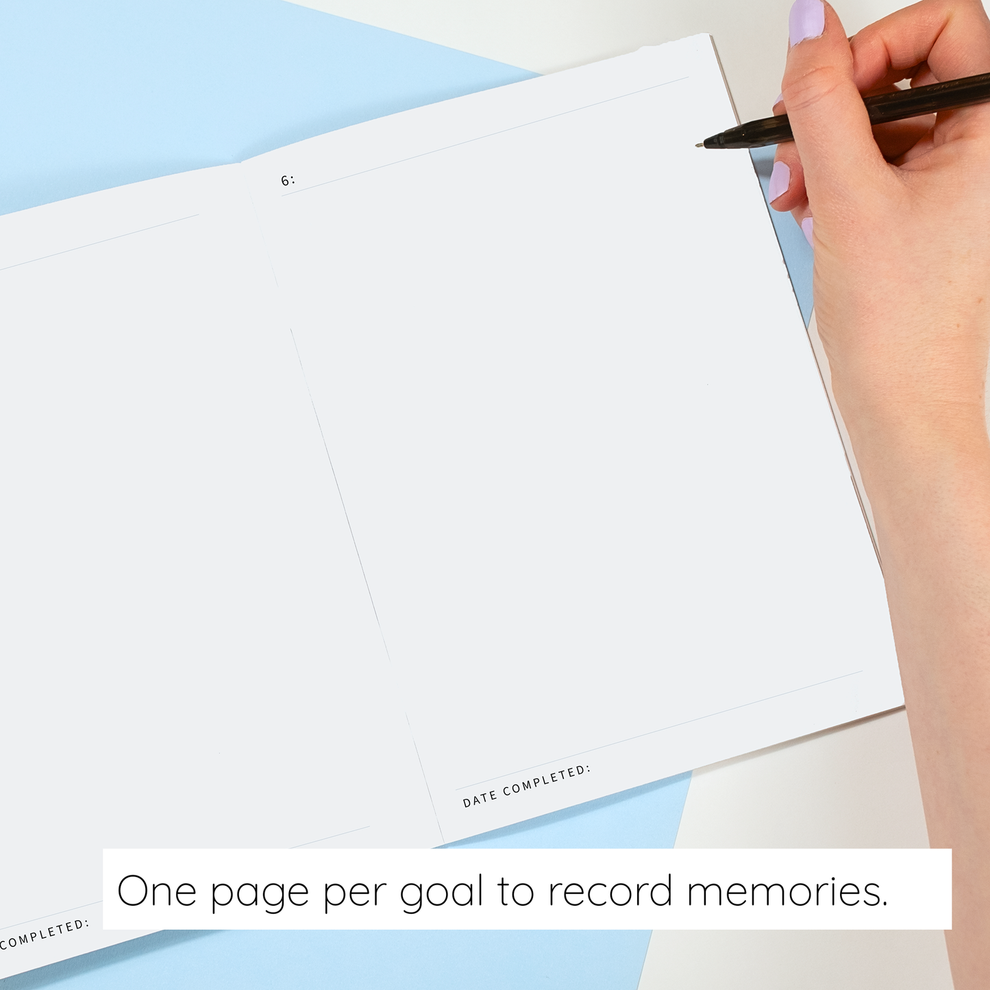 Hand holding a pen over a blank page with text 'One page per goal to record memories.'