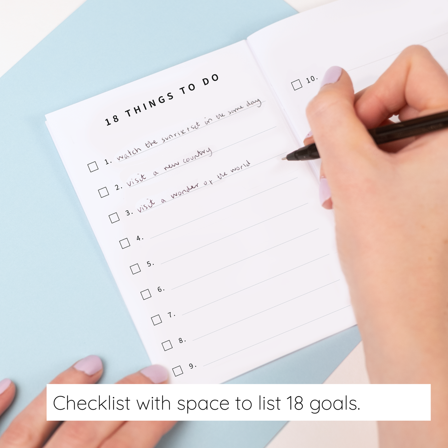 Hand holding a pen over a checklist with space to list 18 goals on a light blue background.